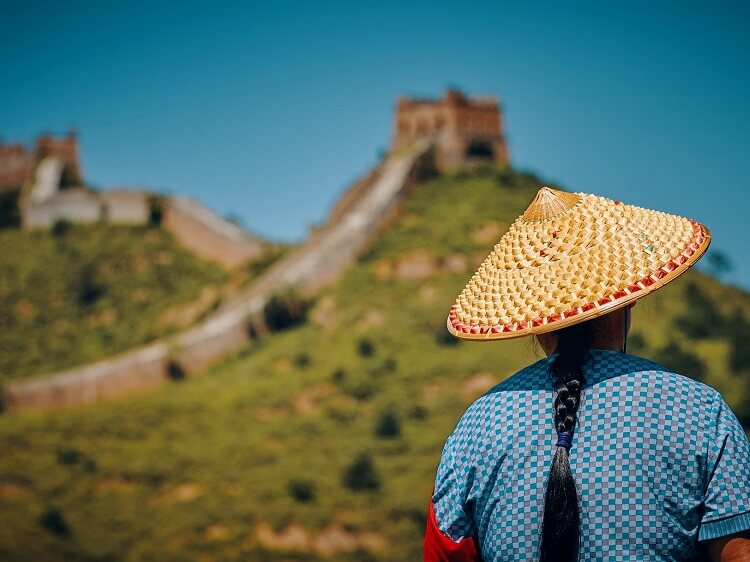 Chinese person wearing traditional hat at Great Wall