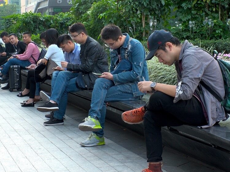 Chinese men looking at their phones