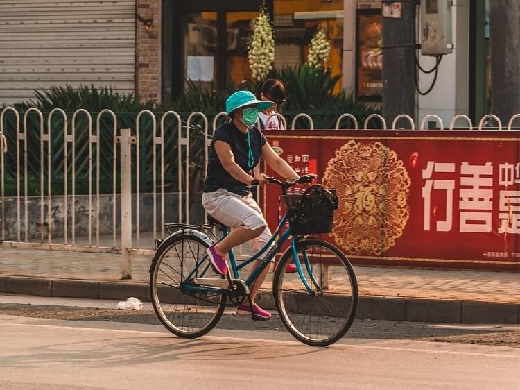 Chinese woman on bike wearing face mask