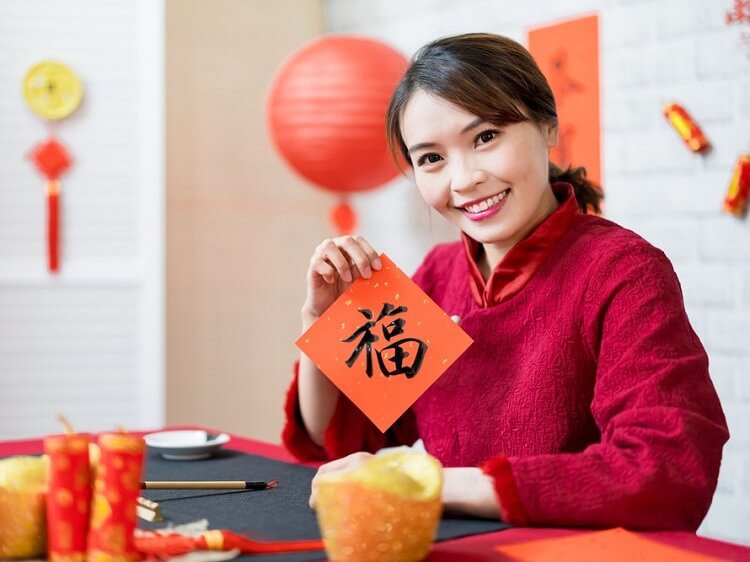 Chinese woman holding lucky fortune sign