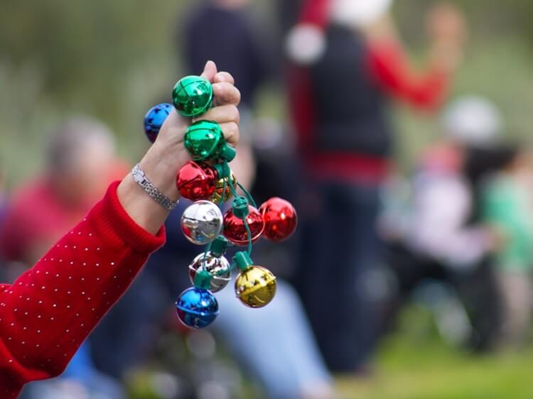 person holding colorful Christmas bells