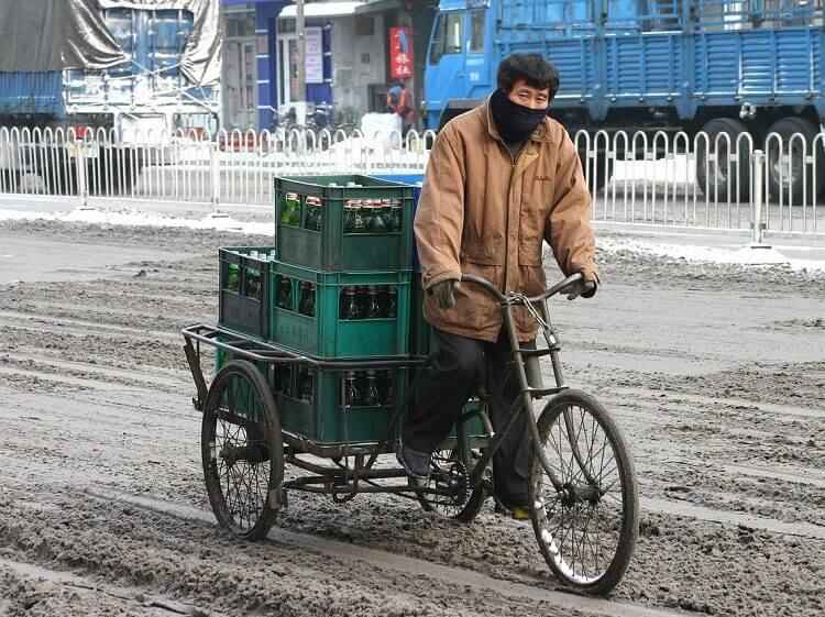 man transporting goods on bicycle in harbin