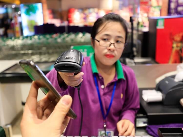 chinese woman scanning a phone for payment
