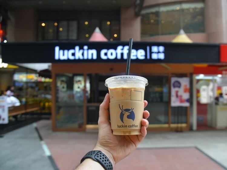 holding a cup of Luckin coffee outside the coffee shop