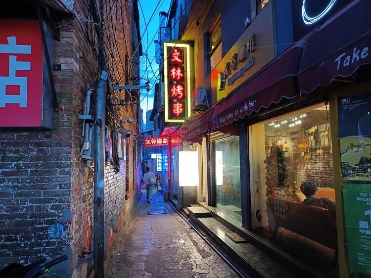 kunming alley at night with neon sign