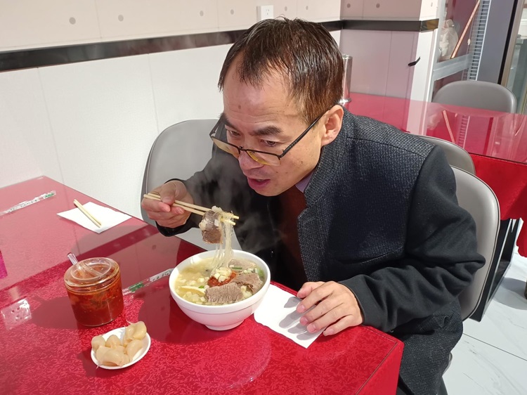 Chinese person eating mutton soup