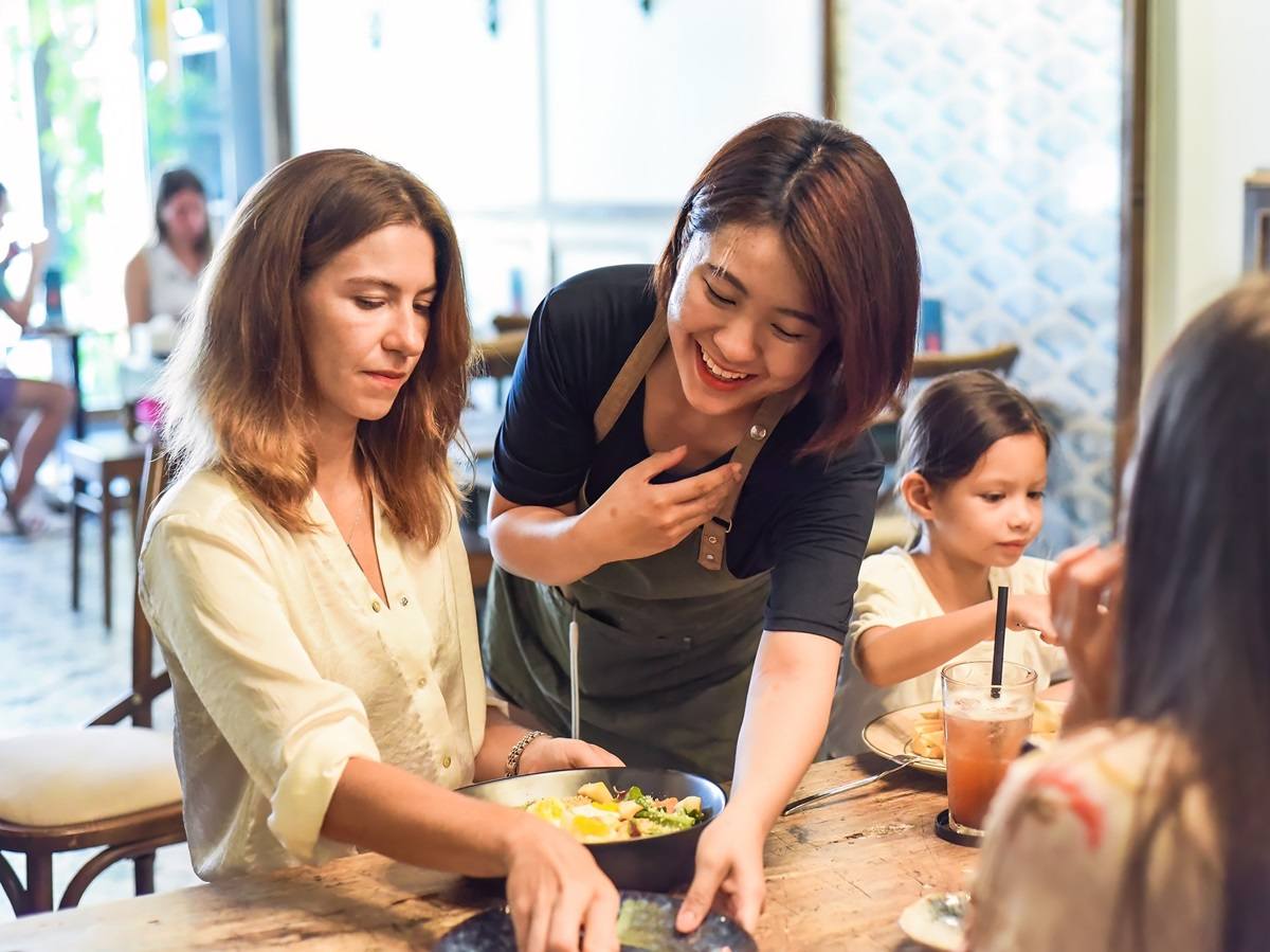 Taiwanese woman helping a foreign woman in a restaurant